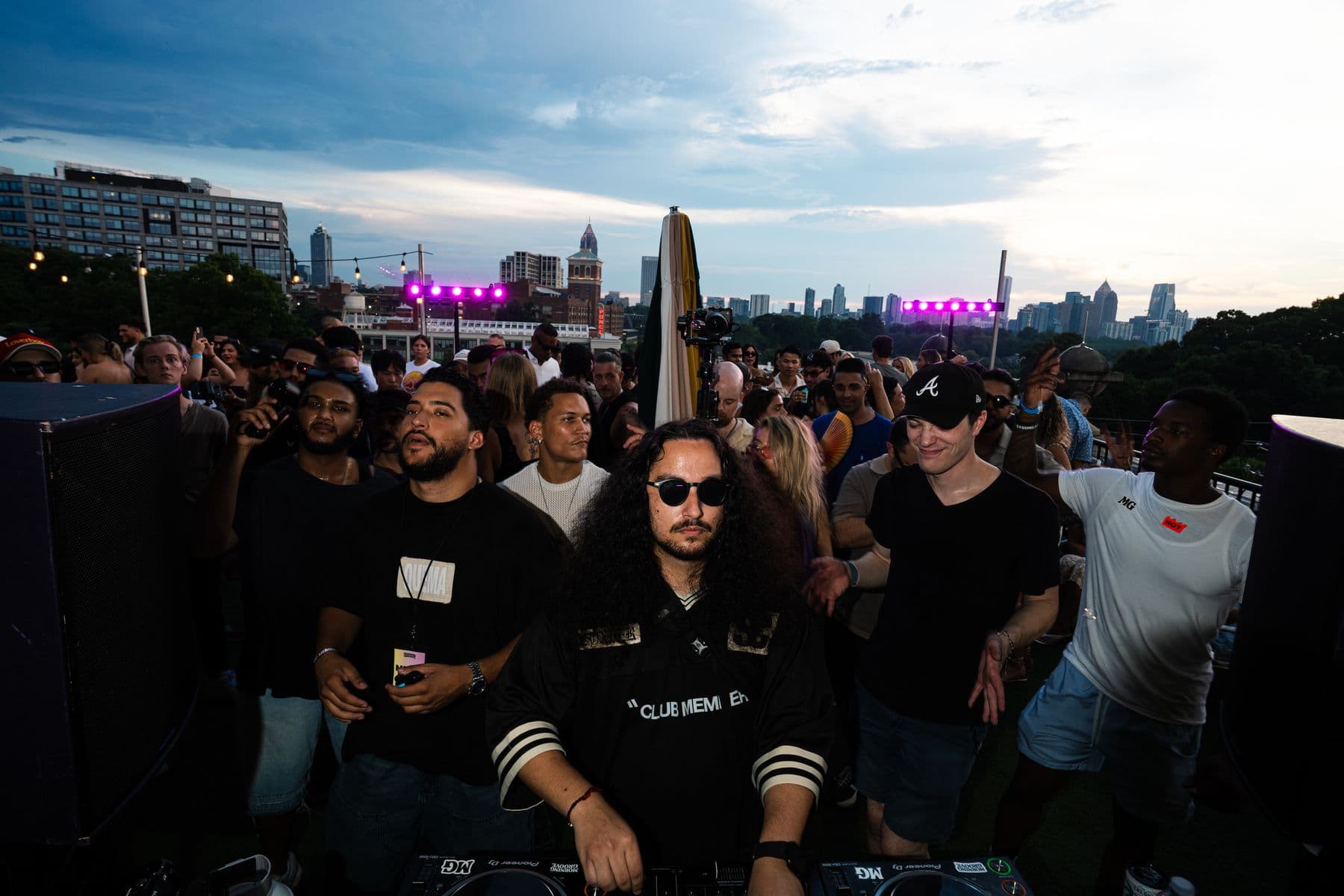 ANÜ at the decks with the crowd and skyline at dusk