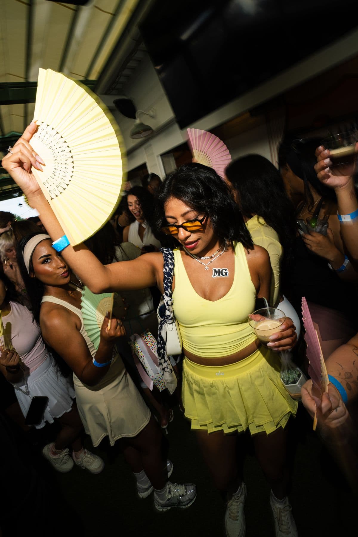 A dancer in yellow with a hand fan
